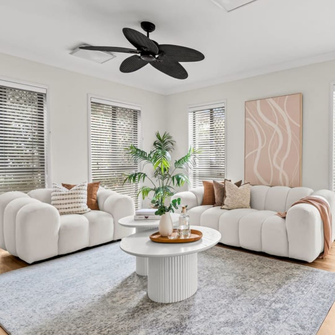 Professionally styled living room with neutral furniture and warm decorative accents